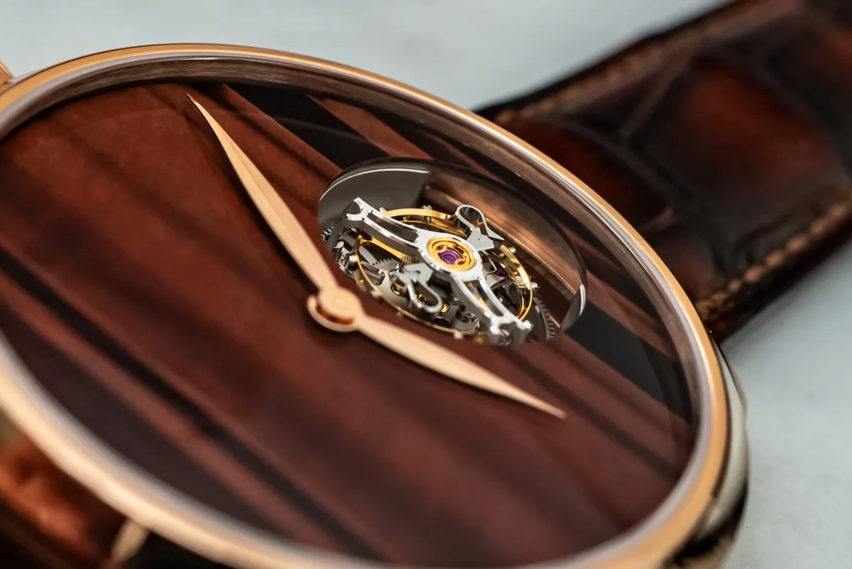 Close-up of the H. Moser & Cie watch hands on a tiger’s eye dial