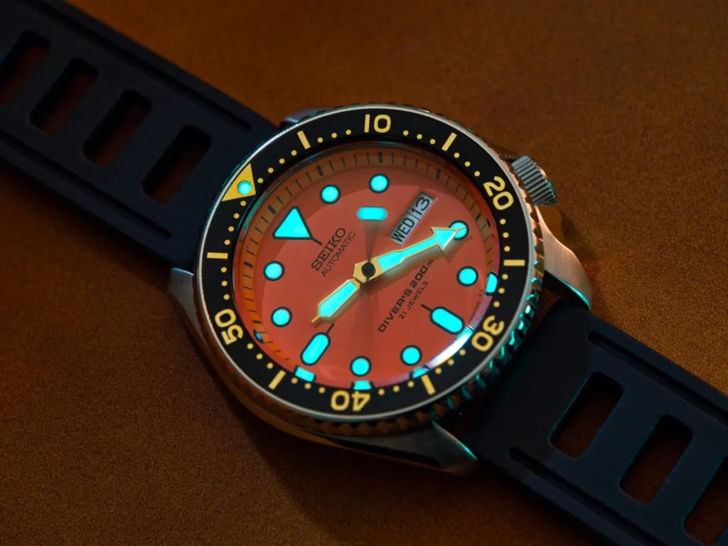 Seiko SKX011 watch with orange dial and luminous hands
