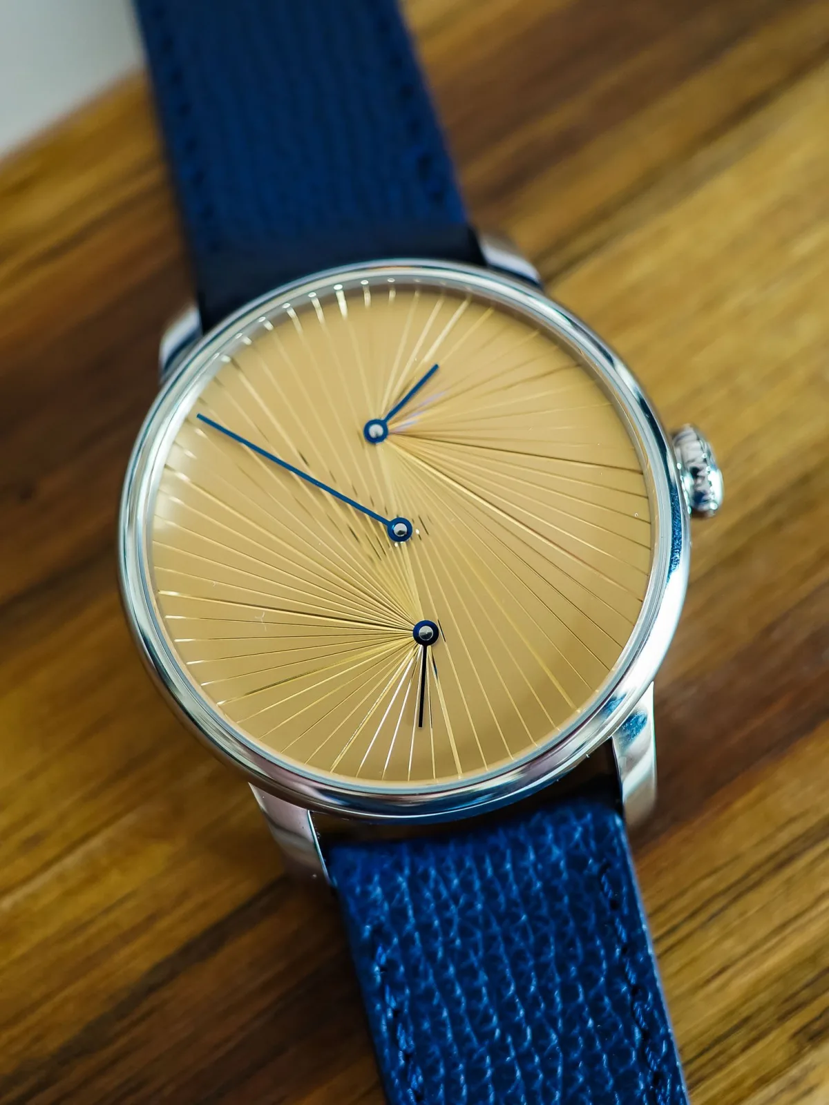 Close-up of gold dial with engraved rays catching sunlight