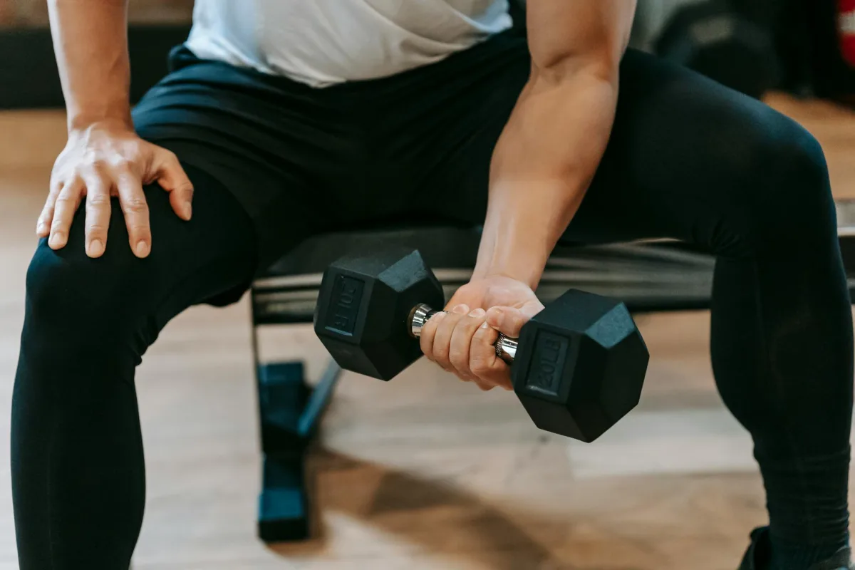 Man performing wrist curls with dumbbells
